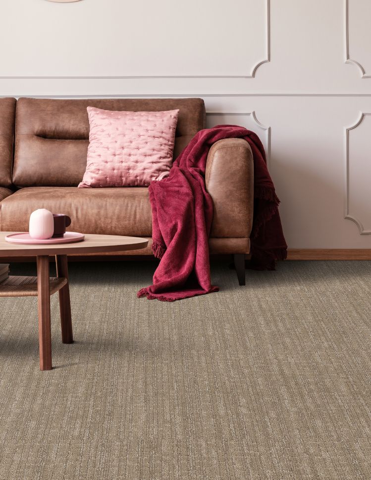 brown textured carpets in a living room with brown leather couch and pink accent wall