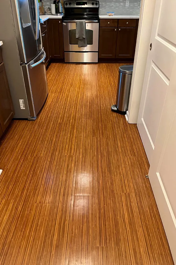 Galley style kitchen with narrow plank amber-colored flooring 