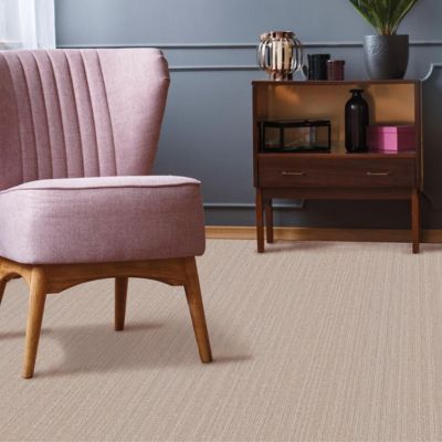 textured beige carpets in a Mason City living room with pink accent chair and grey wall